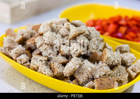 Crackers per insalata Caesar. Pezzi di pane nella ciotola gialla Foto Stock