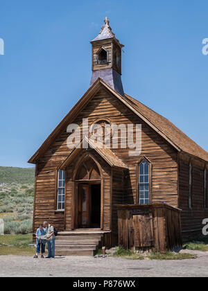 Perplesso giovane verificare la loro mappa di fronte la Chiesa Metodista, Bodie ghost town, Bodie State Historic Park, California. Foto Stock