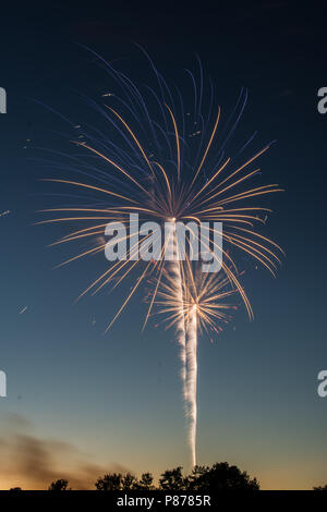 Vivaci fuochi d' artificio esplosioni nel cielo notturno al tramonto. Foto Stock