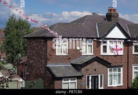 St George cross ed sulle bandiere bianche, battenti in una strada residenziale Grappenhall, Warrington, Cheshire, North West England, Regno Unito Foto Stock