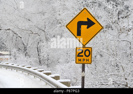 Sharp curva a destra segno e velocità ridotta segno. 20 MPH Foto Stock