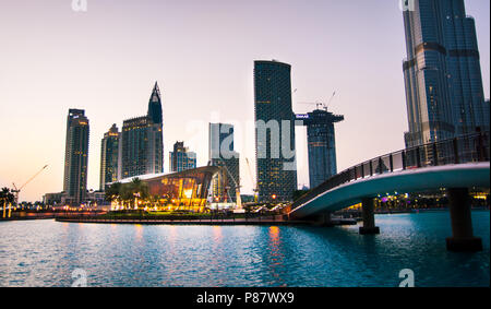 Dubai, Emirati Arabi Uniti - 18 Maggio 2018: Dubai opera edificio e moderni grattacieli del centro commerciale di Dubai dintorni al tramonto Foto Stock