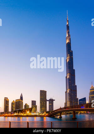 Dubai, Emirati Arabi Uniti - 18 Maggio 2018: opera di Dubai e Burj Khalifa che salgono sopra i moderni grattacieli del centro commerciale di Dubai dintorni al tramonto Foto Stock