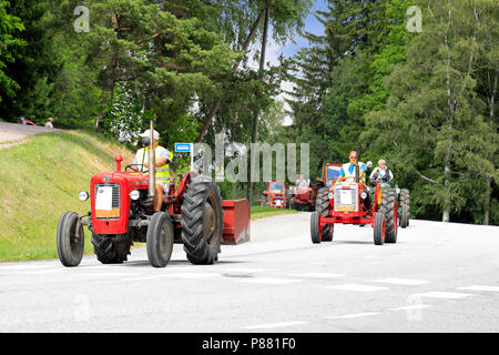 Trattori d'epoca drive in processione attraverso Kimito comunità di Kimito Tractorkavalkad, Cavalcata del trattore. Kimito, Finlandia - Luglio 7, 2018. Foto Stock