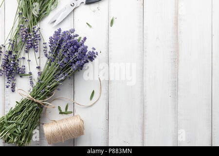 La composizione di legame e bellissimi fiori di lavanda bouquet bianco su tavole di legno sfondo, vista dall'alto Foto Stock