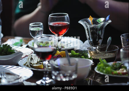 Tavolo nel ristorante con snack e bicchieri di vino rosso. Foto Stock