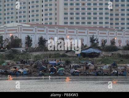 Il contrasto di hotel di lusso e barche da pesca e la povertà delle minoranze musulmane lungo il fiume Mekong in Phnom Penh Cambogia Foto Stock