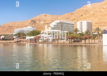 La spiaggia e gli hotel sul mar morto a Ein Bokek in Israele con delle montagne del deserto in background Foto Stock