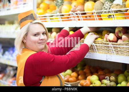 La Bielorussia, Gomel, 24 aprile 2018. Il negozio è centrale. La commessa in un supermercato vicino a mensola con frutta.Il venditore in un supermercato con la compagnia Foto Stock