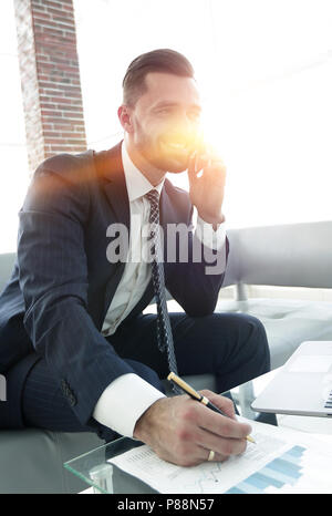 Imprenditore discutendo su uno smartphone, problematiche aziendali Foto Stock