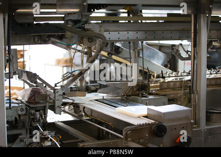 Linea industriale per il confezionamento di prodotti da forno. Confezionamento di pane in fabbrica.La macchina per il taglio e confezionamento in una fabbrica per la produzione Foto Stock