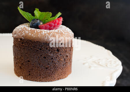 LAVA di cioccolato torta decorata con zucchero a velo e frutta Foto Stock