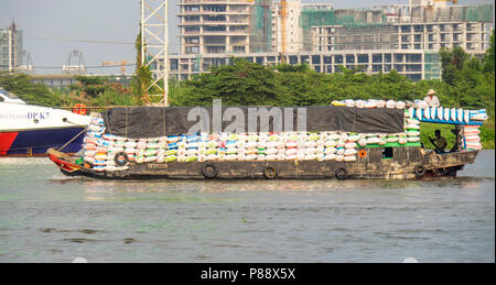 Una chiatta trasporta un carico alla rinfusa sul fiume Saigon Ho Chi Minh City, Vietnam. Foto Stock