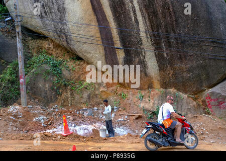 Lavoratori edili provenienti dal Myanmar sono la costruzione di nuove strade attraverso la giungla che copre le montagne dell'isola thailandese di Koh Phangan, Thailandia Foto Stock