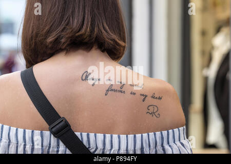 Tatuaggio di parole, sempre nella mia mente, per sempre nel mio cuore e sulle giovani donne spalla posteriore, Lucca, Toscana, Italia, Europa Foto Stock