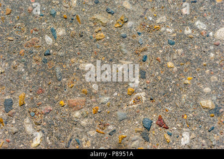 Vista ingrandita di un concreto modello di texture con ciottoli colorati o ghiaia inserita nel cemento. Foto Stock