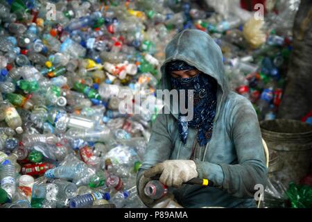 ANGONO, Rizal, Filippine - luglio 4 2018: i lavoratori di un recupero dei materiali facility preparare le bottiglie di plastica per il corretto riciclaggio. Foto Stock