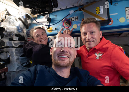 Expedition 57 membri di equipaggio astronauta tedesco Alexander Gerst dell'Agenzia spaziale europea, centro Serena Aunon-Chancellor della NASA, sinistra e Sergey Prokopyev di Roscosmos posano per una foto a bordo della Stazione Spaziale Internazionale Giugno 23, 2018 in orbita intorno alla terra. Foto Stock