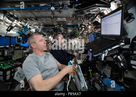 Gli astronauti della NASA Drew Feustel, colore per il primo piano e Ricky Arnold pratica su un simulatore prima di loro prossime manovre di robotica per catturare la SpaceX Dragon commerciale cargo astronave come si arriva alla Stazione Spaziale Internazionale il 26 giugno 2018 in orbita intorno alla terra. Foto Stock