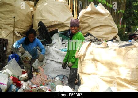 ANGONO, Rizal, Filippine - luglio 4 2018: i lavoratori di un recupero dei materiali facility pongono e sorriso per la fotocamera. Foto Stock