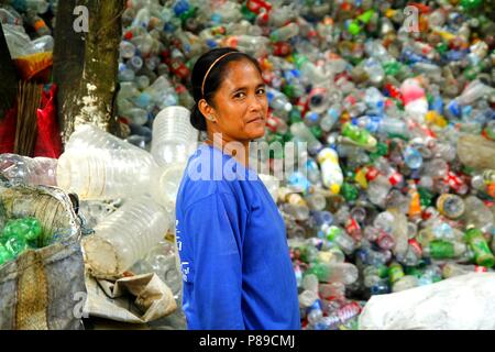 ANGONO, Rizal, Filippine - luglio 4 2018: i lavoratori di un recupero dei materiali facility pongono e sorriso per la fotocamera. Foto Stock