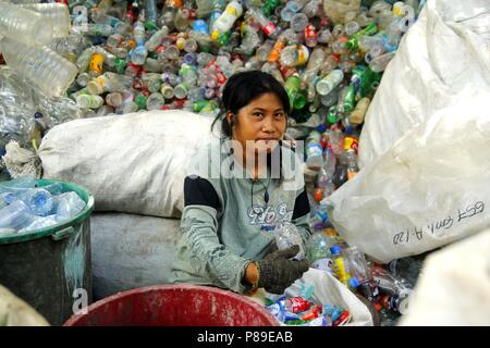 ANGONO, Rizal, Filippine - luglio 4 2018: i lavoratori di un recupero dei materiali facility pongono e sorriso per la fotocamera. Foto Stock