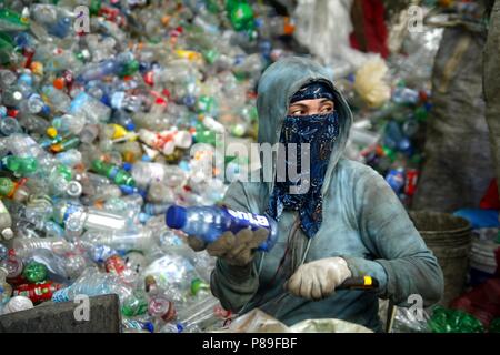 ANGONO, Rizal, Filippine - luglio 4 2018: i lavoratori di un recupero dei materiali facility preparare le bottiglie di plastica per il corretto riciclaggio. Foto Stock