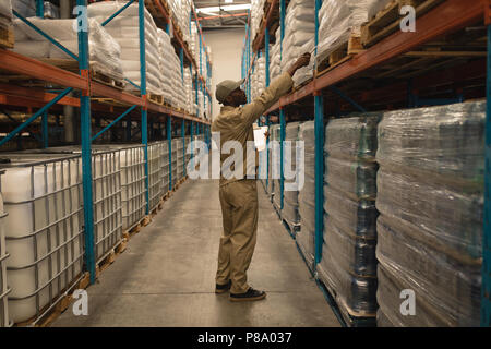 Lavoratore il controllo delle scorte in magazzino Foto Stock