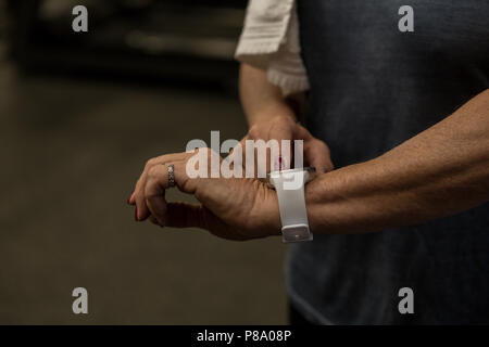 Donna che utilizza smartwatch in palestra Foto Stock
