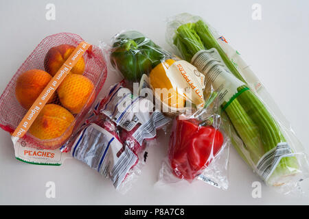 Selezione di frutta e verdura con inutili plastici monouso Foto Stock