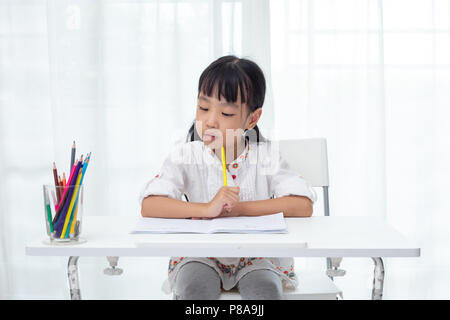 Asian poco ragazza cinese di fare i compiti a casa Foto Stock