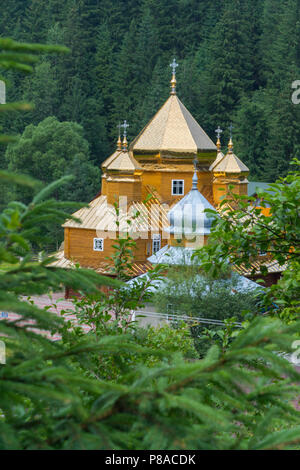 Una bella chiesa di legno immerso nel verde della natura e gli alberi di spessore con cupole che oro colato in sun. . Per il vostro design Foto Stock