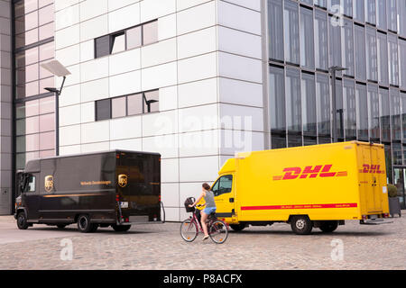 DHL parcel service e UPS Parcel service auto di fronte della gru Casa Sud a Rheinau Harbour, Colonia, Germania. DHL und UPS Fahrzeuge vor dem Kranh Foto Stock