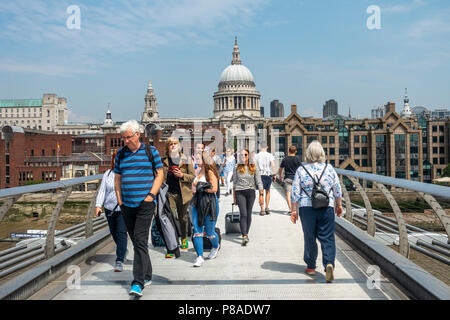 I passeggeri che attraversano la London Millennium Footbridge / Millennium Bridge sul fiume Tamigi verso la Cattedrale di St Paul e nel centro di Londra, Inghilterra Foto Stock