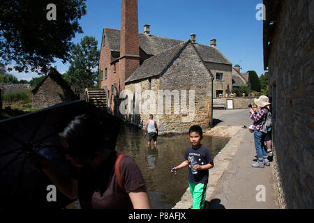 Abbassare la macellazione in Cotswolds, Regno Unito. Lower Slaughter villaggio è costruito su entrambe le rive del fiume occhio, una lenta corrente, attraversata da due passerelle. All'estremità ovest del villaggio vi è un ottocentesco mulino ad acqua con un waterwheel undershot e un camino per ulteriore potenza vapore. Mentre il mulino è costruito di mattoni rossi la maggior parte del XVI e XVII secolo le case nel villaggio di utilizzare Cotswold stone. Il nome del paese deriva dal vecchio termine inglese 'Lough" con il significato di "terra umida". I Cotswolds è una zona di South Central England. La zona è definita dalla roccia di calcare Foto Stock