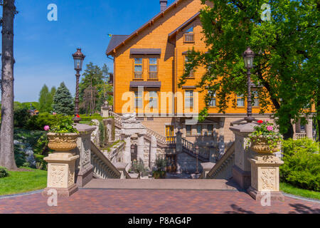 Una bella scala con gradini con una bella architettura portando a casa con grandi ciotole con fiori freschi in piedi su piccoli stand con st Foto Stock