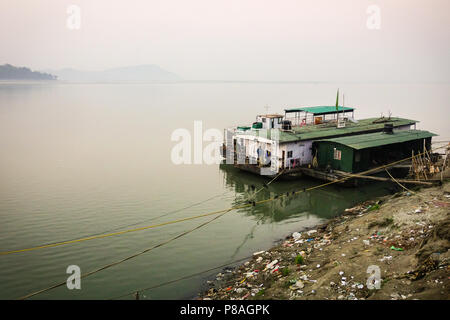 Bella vista del fiume Brahmaputra alle navi da crociera ancorato alla plastica shore inquinato a Guwahati, Assam, India. Foto Stock