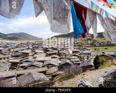 Guardando verso il basso sulla città vecchia di Zhongdian in Shangri-La, Cina, dall'alto della collina sacra con la preghiera le bandiere Foto Stock