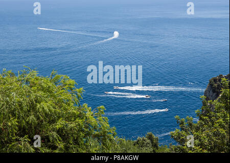 Le imbarcazioni da diporto a giocare sulla costa orientale di Capri ITALIA Foto Stock