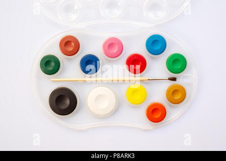 Vista dall'alto di un acquarello scuola paintbox. Tavolozza di vernice con la spazzola. Si torna a scuola il concetto dei materiali di consumo. Foto Stock