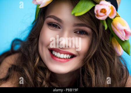 Close-up verticale di felice giovane donna con corona fatta di tulip fiori Foto Stock