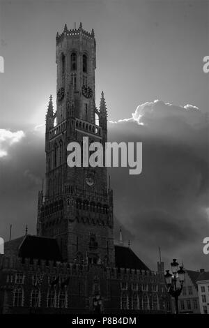 Il vertiginoso aumento del gotico Belfort, o torre campanaria del Hallen domina il Markt, Brugge, Belgio. Versione in bianco e nero Foto Stock