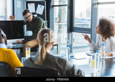 Imprenditore che mostra qualcosa a schermo del computer durante la riunione in ufficio Foto Stock