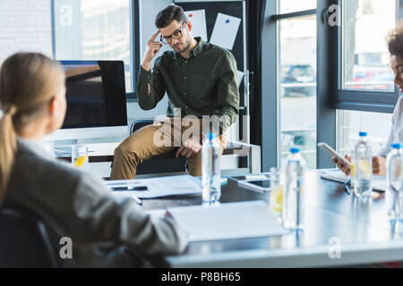 Imprenditore gesti ai colleghi durante la riunione in ufficio Foto Stock