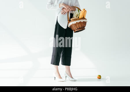 Vista ravvicinata di moda donna cestello di trasporto con pane e fiori Foto Stock