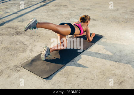 Vista posteriore di sportive facendo esercizi aerobici sul tappetino fitness Foto Stock