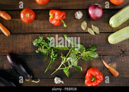 Set di verdure diverso per la cottura di ratatouille. Ortaggi vari in legno scuro, tabella, vista dall'alto Foto Stock