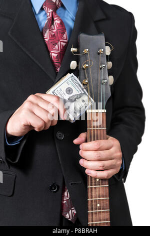 Imprenditore tenendo un fascio di dollari vicino le corde di una chitarra, close-up Foto Stock