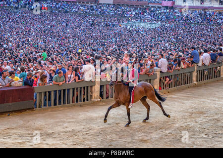 Un fantino sfilano di fronte al pubblico prima del Palio, Piazza del Campo a Siena, Italia Foto Stock