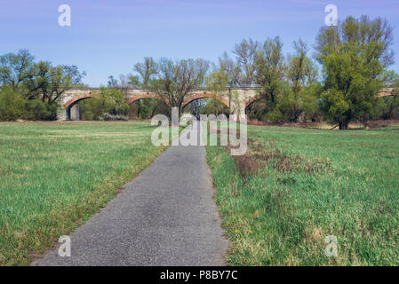 Pista ciclabile accanto al ponte ferroviario oltre il fiume Morava tra Slovacchia e Austria vicino a Devinska Nova Ves, Bratislava Foto Stock